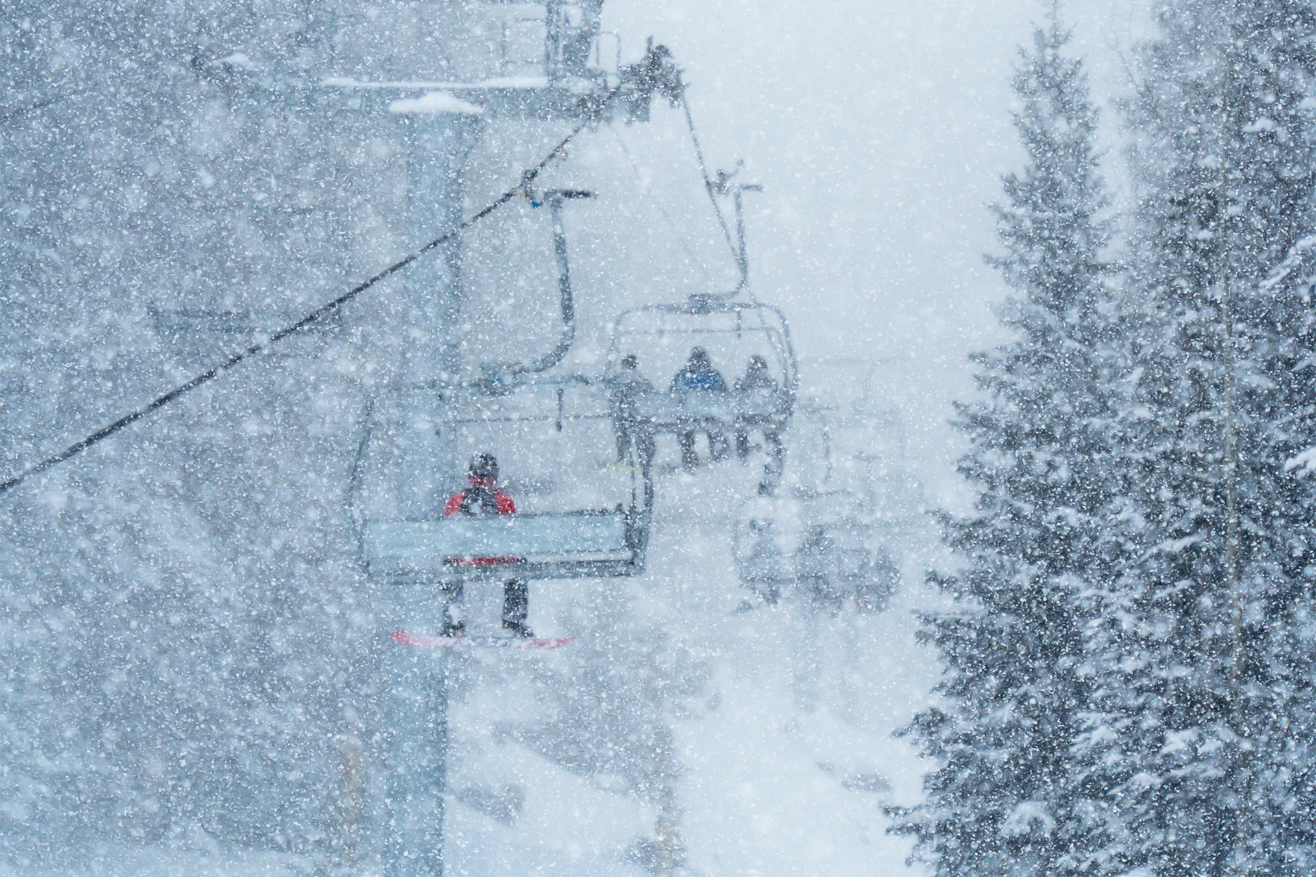 snowboarders on the ski lift during a heavy snowstorm